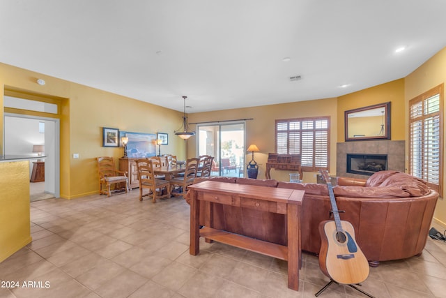 living room with light tile patterned floors and a tile fireplace