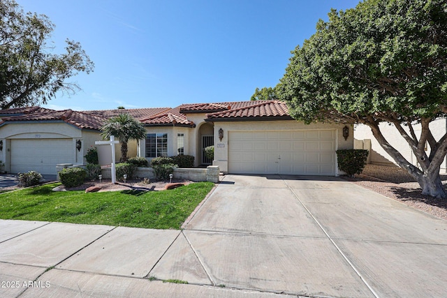 mediterranean / spanish-style home with stucco siding, a garage, driveway, and a tiled roof