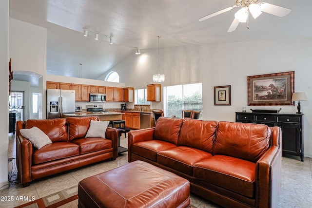 living area featuring high vaulted ceiling, a ceiling fan, arched walkways, light tile patterned flooring, and rail lighting