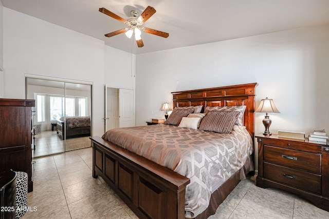 bedroom featuring light tile patterned floors, a ceiling fan, multiple closets, and a towering ceiling