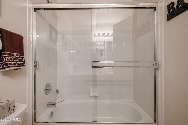 full bath featuring shower / bath combination with glass door and toilet