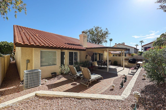 back of house featuring a tiled roof, stucco siding, cooling unit, a fenced backyard, and a patio area