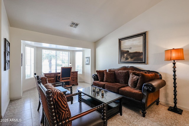 living area with light tile patterned floors, visible vents, baseboards, and vaulted ceiling