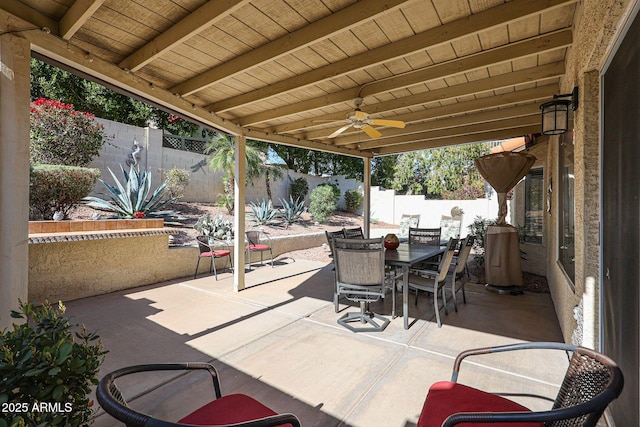 view of patio with outdoor dining space, a fenced backyard, and a ceiling fan