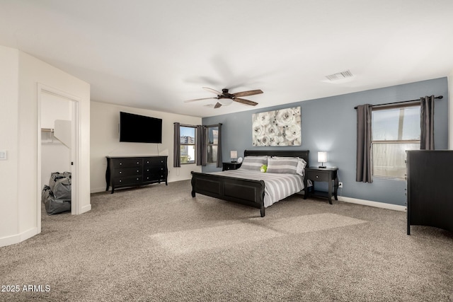 bedroom with a walk in closet, ceiling fan, and carpet