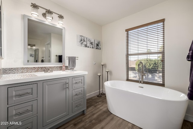 bathroom with backsplash, a bathing tub, vanity, and hardwood / wood-style flooring