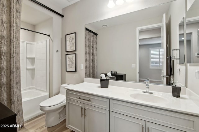 bathroom with vanity, toilet, wood finished floors, and shower / bath combo with shower curtain