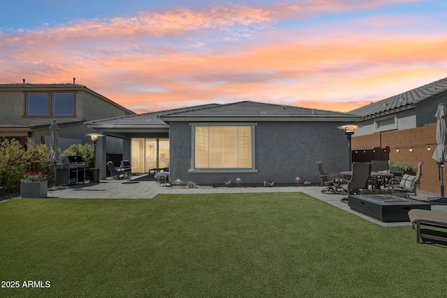 back of house featuring a patio area, stucco siding, a lawn, and fence