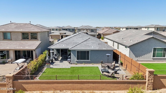 back of house with a patio, a fenced backyard, stucco siding, a lawn, and a residential view