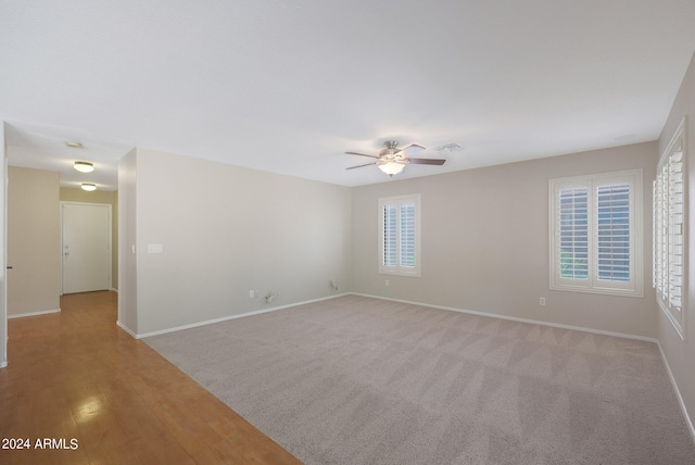 spare room featuring ceiling fan, light wood-type flooring, and plenty of natural light