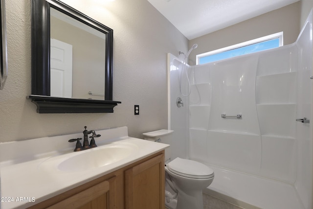 bathroom with walk in shower, vanity, and toilet