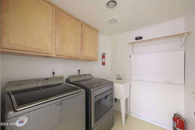 washroom featuring washer and dryer and cabinets