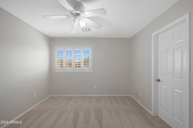 carpeted spare room featuring ceiling fan