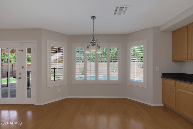 unfurnished dining area featuring light hardwood / wood-style flooring and a chandelier