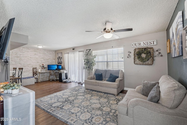 living room featuring ceiling fan, wood finished floors, and a textured ceiling