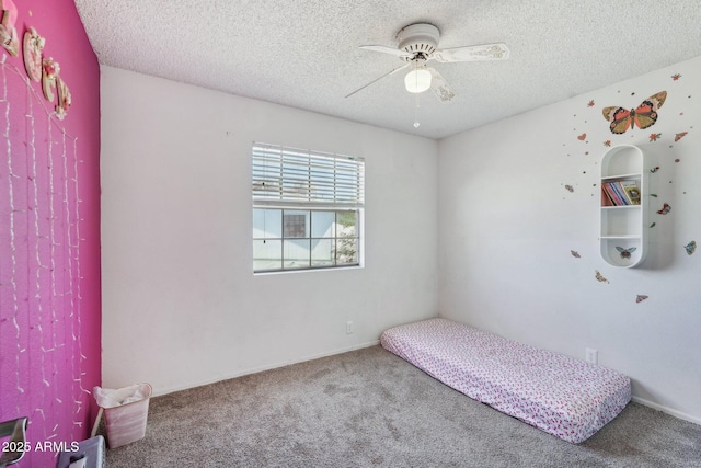 unfurnished bedroom featuring ceiling fan, carpet flooring, and a textured ceiling