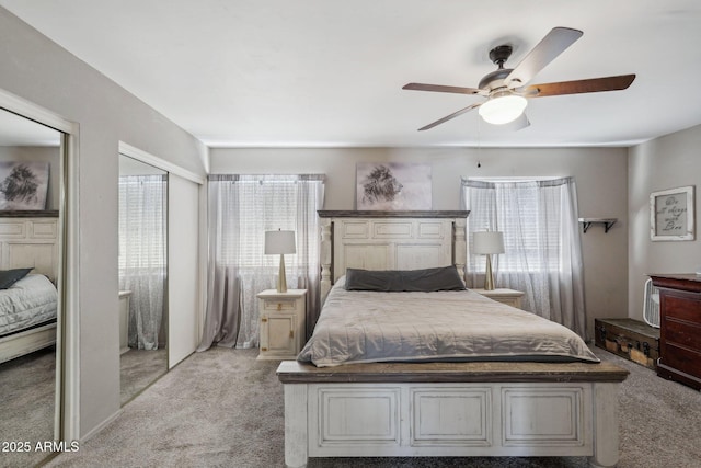 bedroom featuring light carpet, multiple windows, and ceiling fan