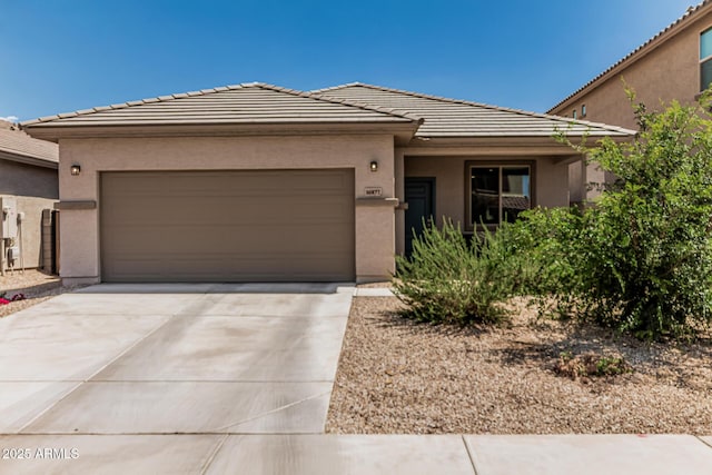 16877 W Butler Ave, Waddell, AZ 85355 - prairie-style house with a garage, stucco siding, a tile roof, and concrete driveway