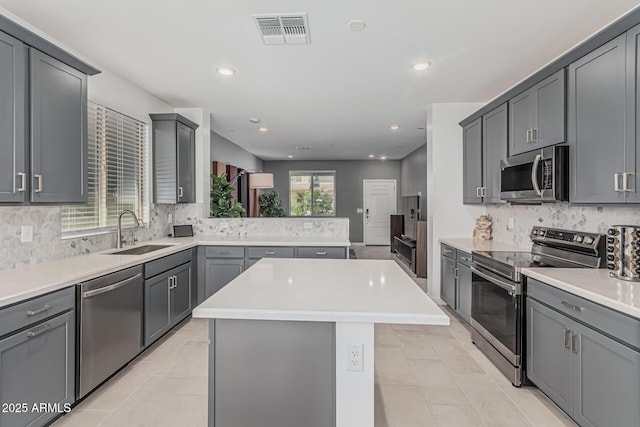 16877 W Butler Ave, Waddell, AZ 85355 - kitchen featuring appliances with stainless steel finishes, a sink, backsplash, a center island, and a peninsula