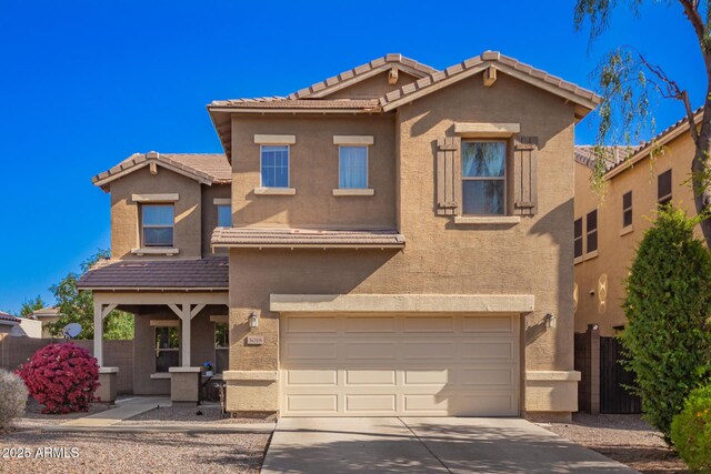 mediterranean / spanish home featuring a garage, driveway, stucco siding, and a tile roof