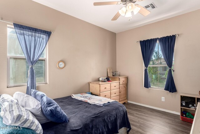 bedroom featuring wood finished floors, ceiling fan, baseboards, and visible vents