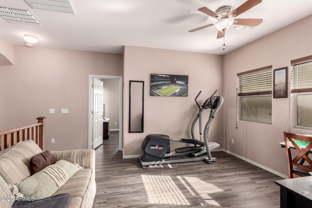 workout room with wood finished floors, baseboards, a ceiling fan, and visible vents