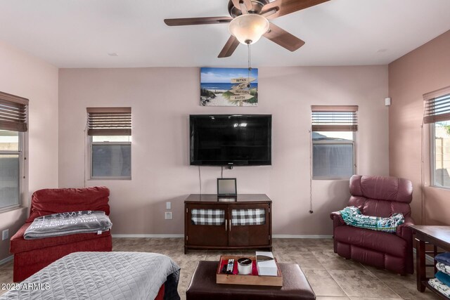 tiled living area featuring ceiling fan and baseboards