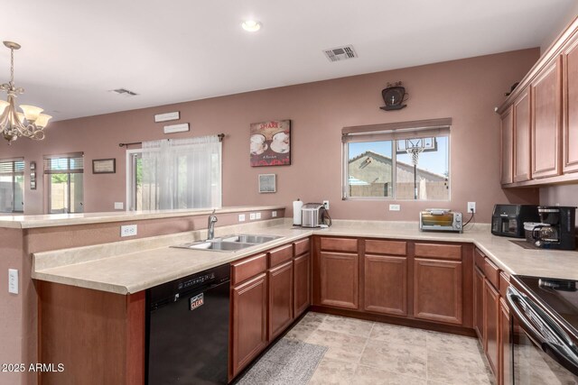 kitchen featuring visible vents, a sink, light countertops, a peninsula, and black appliances