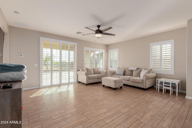 living room featuring light wood-type flooring, plenty of natural light, and ceiling fan