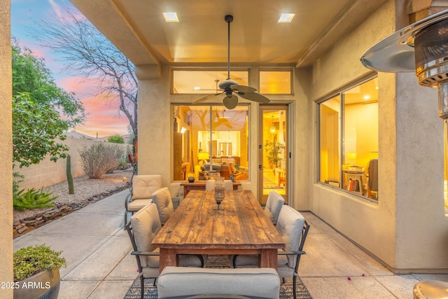 patio terrace at dusk with fence and outdoor dining space