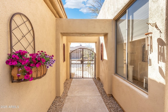 property entrance with stucco siding and a gate