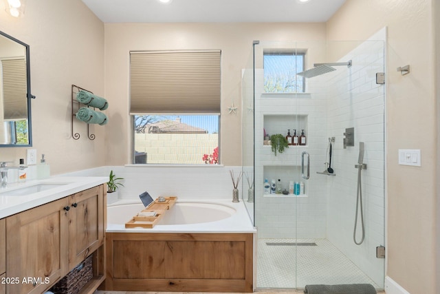 full bathroom with vanity, a garden tub, and a shower stall