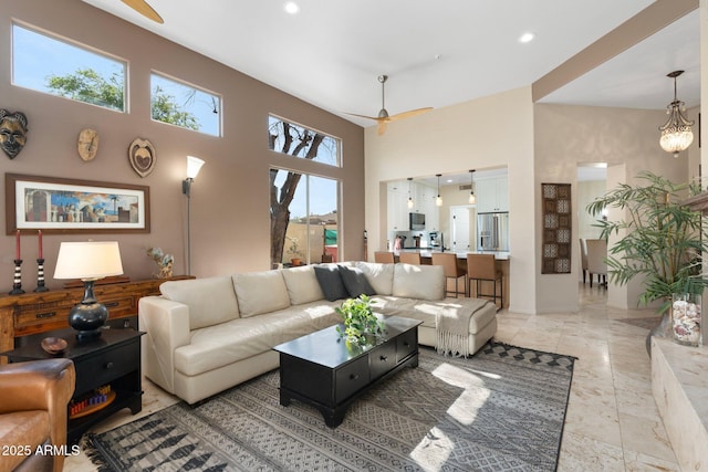 living room with a towering ceiling, recessed lighting, and a ceiling fan