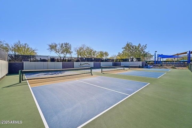 view of tennis court featuring community basketball court and fence