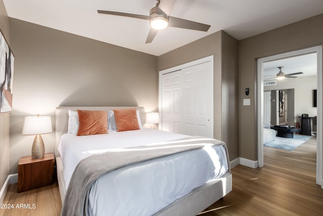 bedroom featuring ceiling fan, wood-type flooring, and a closet