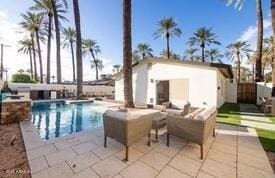 view of pool featuring a patio area, an outdoor living space, and an outbuilding