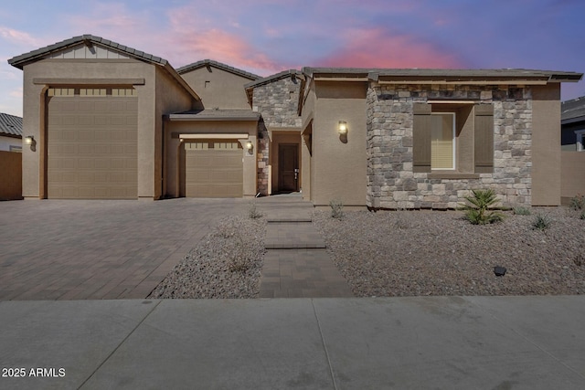7694 W Desert Spoon Dr, Peoria, AZ 85383 - view of front of property with stone siding, an attached garage, driveway, and stucco siding