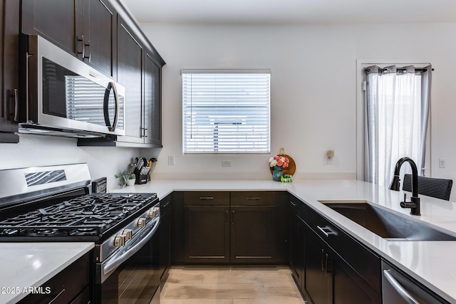 7694 W Desert Spoon Dr, Peoria, AZ 85383 - kitchen with appliances with stainless steel finishes, a sink, light countertops, and dark brown cabinetry