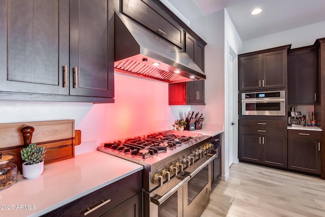7694 W Desert Spoon Dr, Peoria, AZ 85383 - kitchen featuring stainless steel appliances, range hood, light countertops, and light wood-style floors