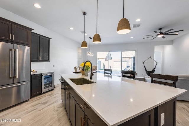 7694 W Desert Spoon Dr, Peoria, AZ 85383 - kitchen featuring high end refrigerator, beverage cooler, a sink, open floor plan, and a kitchen island with sink
