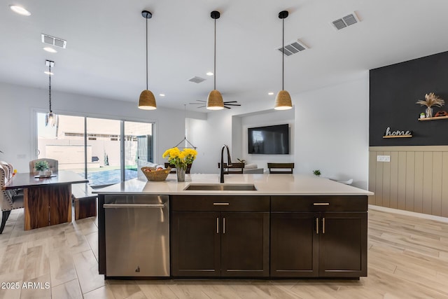 7694 W Desert Spoon Dr, Peoria, AZ 85383 - kitchen featuring a sink, stainless steel dishwasher, light countertops, dark brown cabinets, and a wainscoted wall