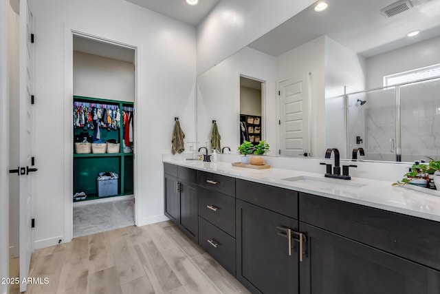 7694 W Desert Spoon Dr, Peoria, AZ 85383 - full bathroom featuring a spacious closet, double vanity, a shower stall, and recessed lighting