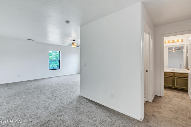 spare room featuring ceiling fan, light colored carpet, and sink