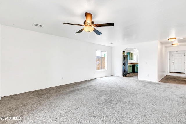 unfurnished living room with carpet flooring and ceiling fan