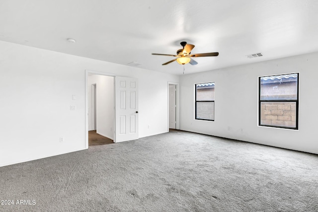 unfurnished room featuring ceiling fan and dark carpet