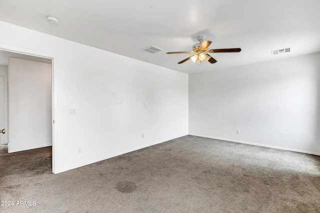 unfurnished room featuring ceiling fan and dark carpet