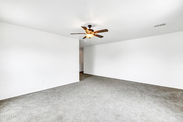 empty room featuring dark carpet and ceiling fan