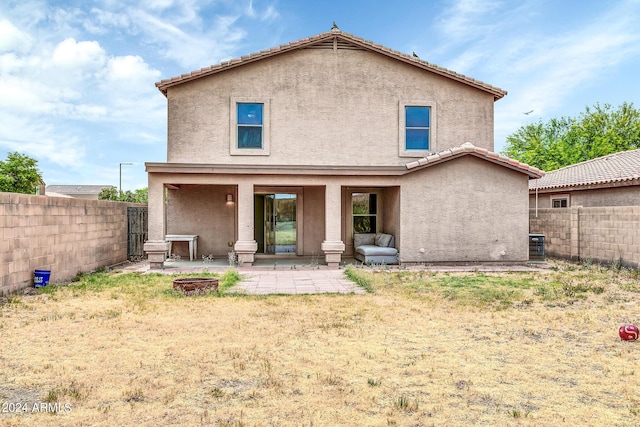 rear view of property with a patio area and an outdoor fire pit