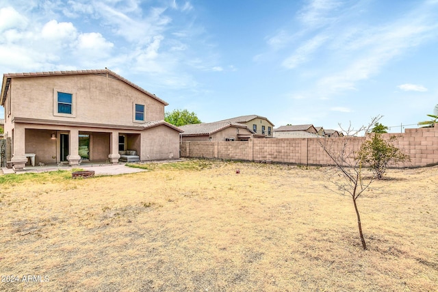 back of property with a patio and a fire pit