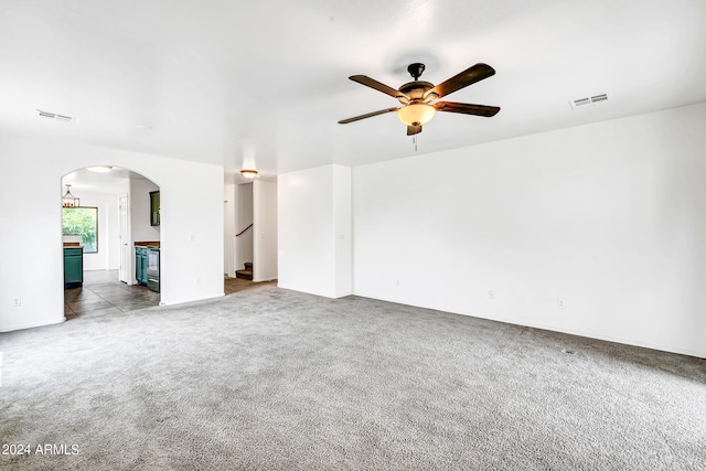 unfurnished living room featuring dark colored carpet and ceiling fan